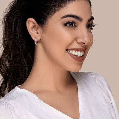 Silver flower hoop earrings on a model